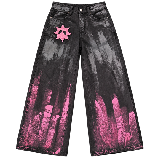 Front view of GOOUNIES black wide-leg jeans with pink and gray brushstroke detailing and a pink face patch